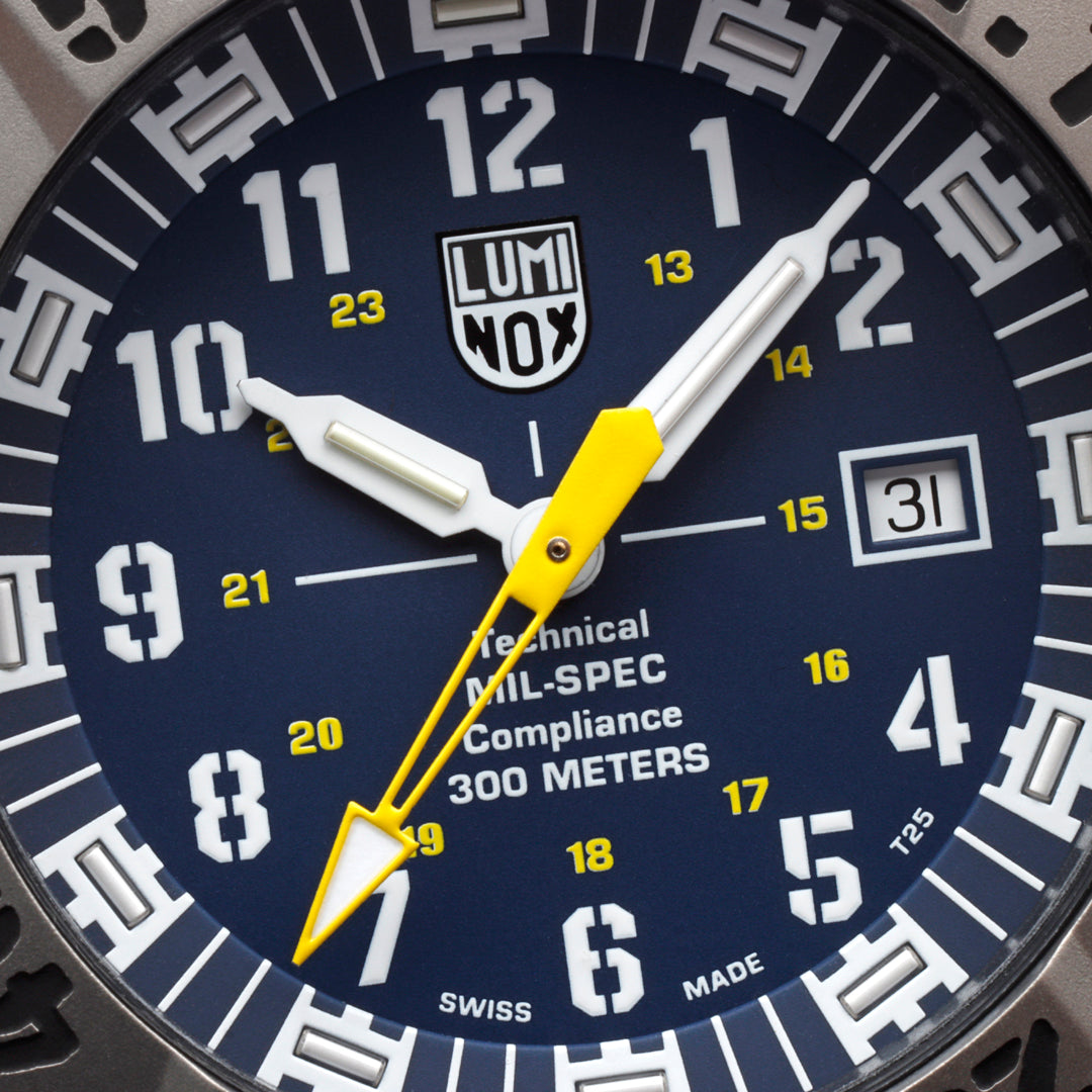 Close-up of a Luminox watch face with blue background and yellow accents.