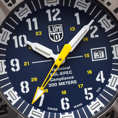 Close-up of a Luminox watch face with blue background and yellow accents.