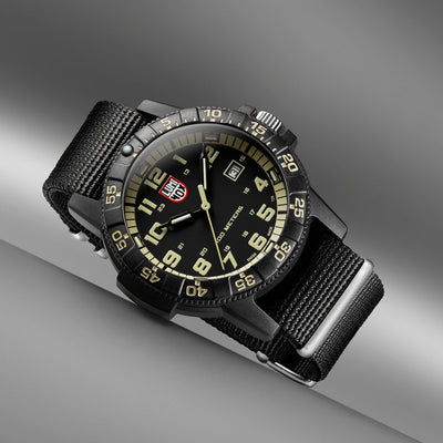 Black wristwatch Luminox with a detailed face on a gray background
