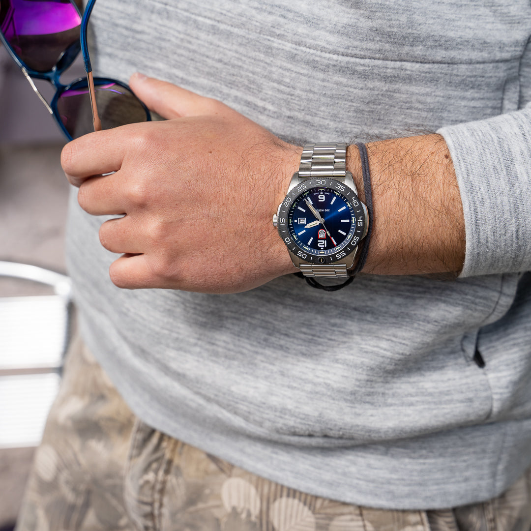 Person wearing a smartwatch with a gray shirt and sunglasses on head