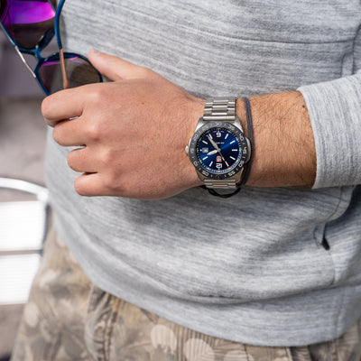 Person wearing a smartwatch with a gray shirt and sunglasses on head