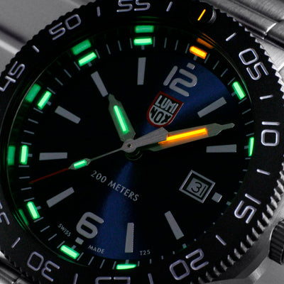 Close-up of a watch face with green glowing elements and a brand logo.